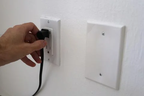 Man hand with electric plug Stock Photos