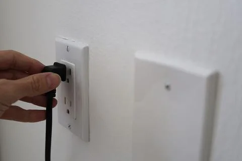 Man hand with electric plug Photos