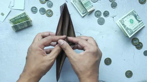 Man hand with empty wallet with pennies small change scattered on table. fiance Stock Footage 336450500