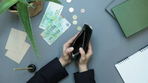 Man hand with empty wallet with pennies small change scattered on table. fiance Stock Footage 336450506