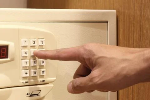 Man hand entering code of safe box Stock Photos