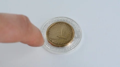Man hand flick one dollar coin out to reveal a bitcoin coin. Stock Footage 99548503