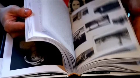 Man hand flips pages and find money in his book Stock Footage 84774875