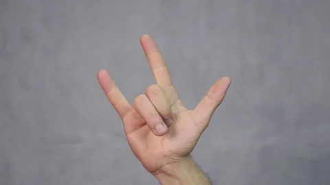 Man hand gesturing horns. Rock and roll gesture sign symbol. Stock Footage 94884636