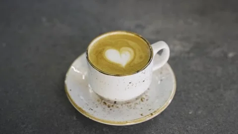 Man hand give cappuccino cup from the table, heart shape on the coffee Stock Footage 241275868