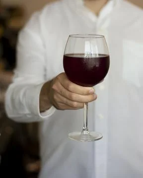 Man hand glass of red wine for health benefits Stock Photos
