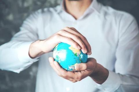 Man hand globe on dark background Stock Photos