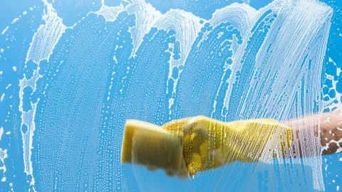 Man hand with glove using sponge to make window clean Stock Photos