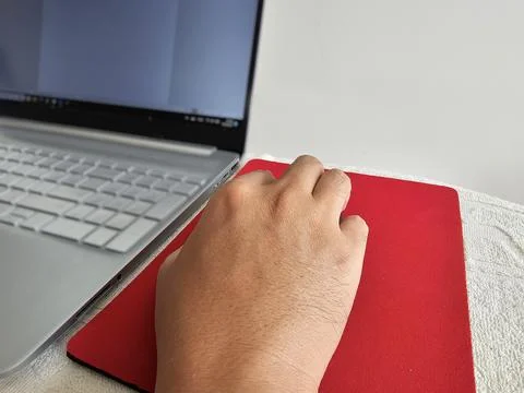 Man hand grips a mouse while operating a Laptop. work from home concept Foto stock