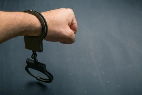 Man hand in handcuffs Stock Photos