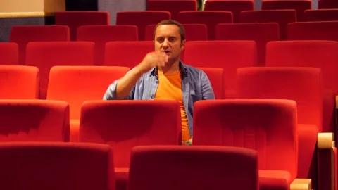 Man with hand on head sitting on empty cinema hall surprised of presentation Video stock 81074123