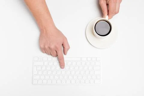 A man hand hold a wireless  keyboard and coffee cup isolated on white. Stock Photos