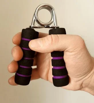 Man hand holding and using a hand grip strengthener Stock Photos