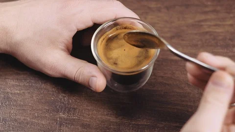 Man hand holding coffee cup, pouring sugar and drinking espresso. Video stock 112679792