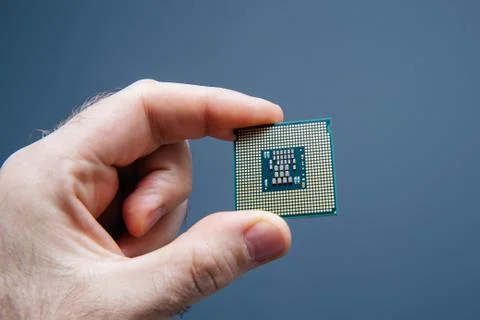 Man hand holding CPU Central processing unit gray background 스톡 사진
