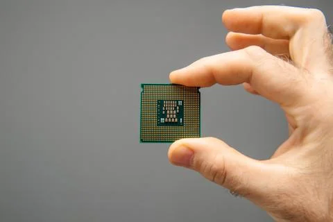 Man hand holding CPU Central processing unit gray background 스톡 사진