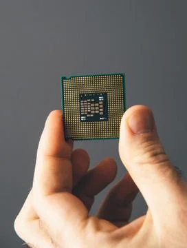 Man hand holding CPU Central processing unit gray background 스톡 사진