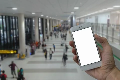 A man hand holding empty screen of smart phone and blur airport terminal back Stock Photos