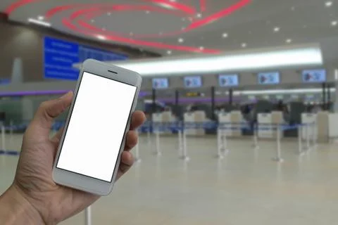 A man hand holding empty screen of smart phone and blur check-in counter airp Stock Photos
