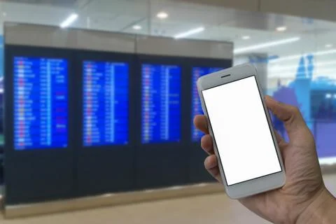 A man hand holding empty screen of smart phone and blur Flight Schedule in th Foto stock