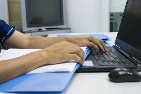 Man hand holding files document and typing computer keyboard notebook Stock Photos