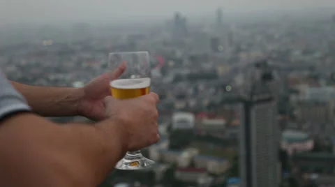 Man hand holding mug of beer in sky deck pub Stock Footage 62523447