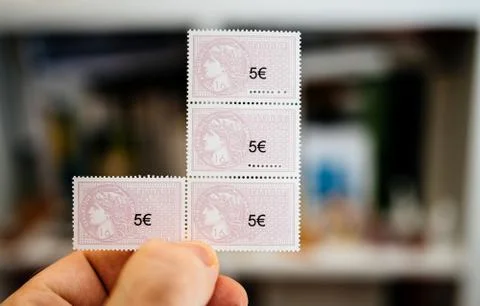 Man hand holding multiple 5 euro fiscal revenue stamp Photos