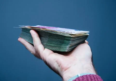 Man hand holding pile stack of euros dollars currency thousands Stock Photos