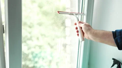 Man hand holding a professional window cleaning squeegee tool against glass.. Vídeos de archivo 340159321
