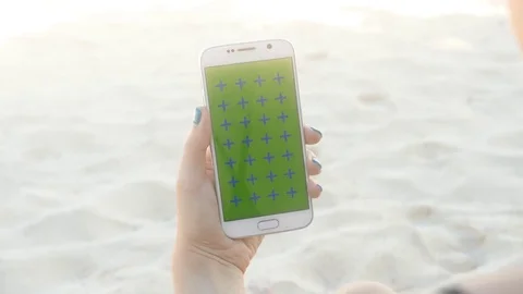 Man hand holding white mobile vertical on the beach Stock Footage 76027207