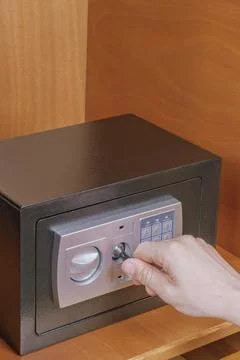 Man hand inserting emergency override master key into electronic safe box l.. Stock Photos