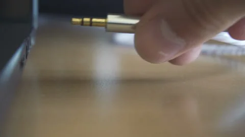 Man hand inserting headphones cable into audio jack insert. Close up shot Stock Footage 87976121