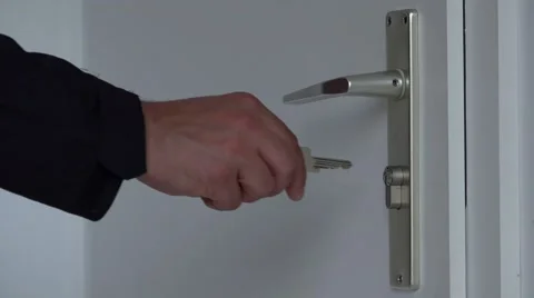 Man hand with keys opening with big difficulty the white door 4k Stock Footage 46213945