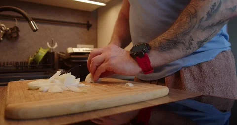 A man hand with a knife is preparing dinner. brown onion cuting to be sauteing Stock Footage 264585011