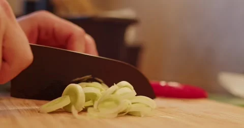 A man hand with a knife is preparing dinner. leek cuting to be sauteing. Leek on Stock Footage 264585100