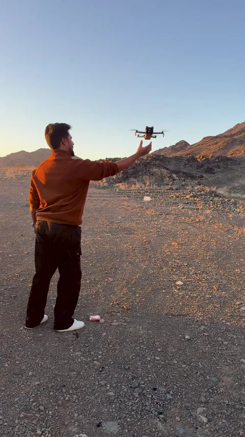 Man Hand-Launching Drone in Desert Landscape at Sunset Vídeo Stock 329680381
