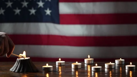 Man hand light candle for honoring and mourning with American flag background Stock Footage 296986874