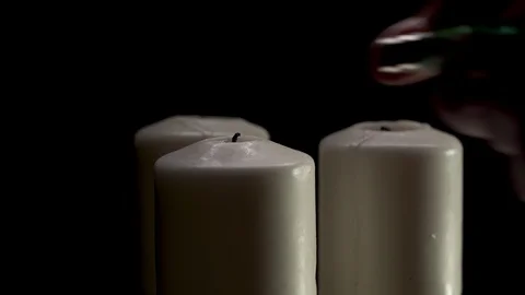 Man hand light three white candles. rotate on the table. Black background Stock Footage 127002252