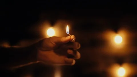 Man hand lights a candle inside a Halloween pumpkin with a match in dark room. Stock Footage 117490560