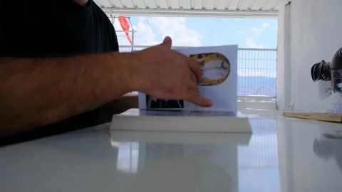 A man hand opens a book and it is on the white and shine polishing surface Stock Footage 156274842