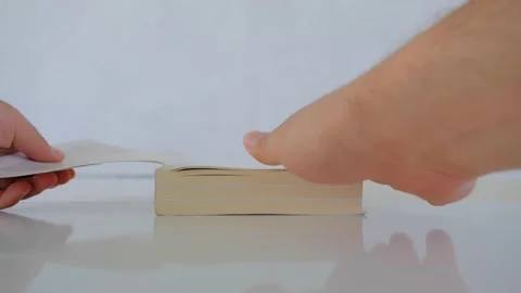 A man hand opens a book and it is on the white and shine polishing surface Stock Footage 156274957