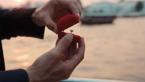 Man hand opens box with elegant engagement ring on yacht against bay closeup Stock Footage 309047636