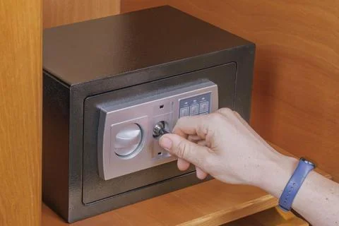 Man hand opens electronic safe box using emergency key overcome dead batter.. Stock Photos