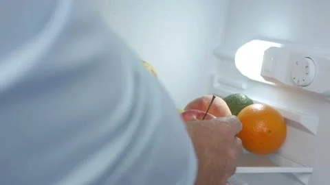 Man Hand Opens Kitchen Fridge Door and Put Inside an Apple. Empty Fridge Stock Footage 311336279