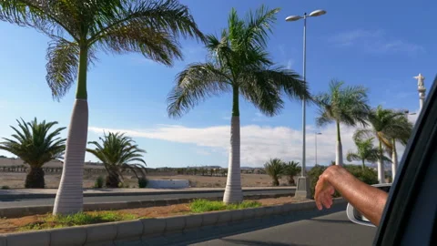 Man with hand out of window while driving along street in 4k slow motion 60fps Stock Footage 131000456