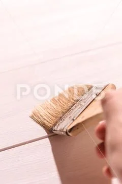Man hand with a paintbrush on wooden background Stock Photos