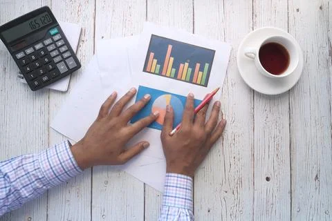Man hand with pen analyzing bar chart on paper Stock Photos