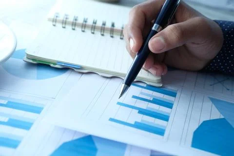 Man hand with pen analyzing bar chart on paper Stock Photos