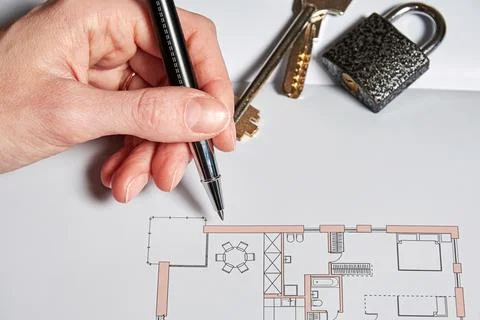 Man hand with a pen, flat layout draft, lock and keys Stock Photos