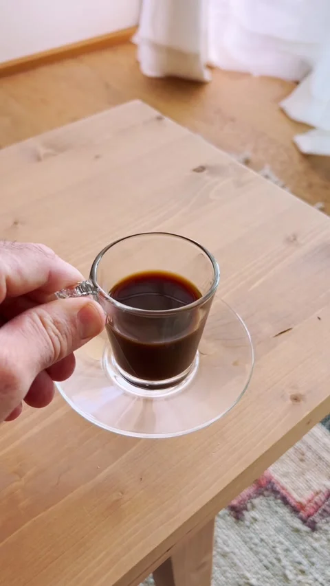 Man hand picking up a fresh espresso coffee cup from a wooden table Stock Footage 345369986